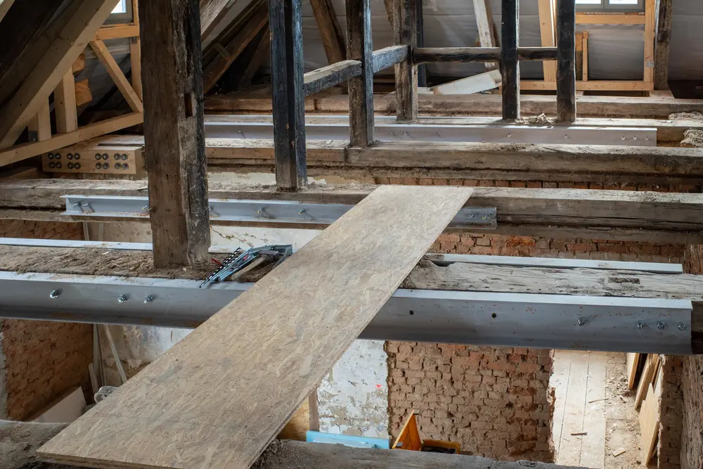 Dans l'ancien bâtiment, de vieilles poutres en bois sont renforcées de poutres en acier