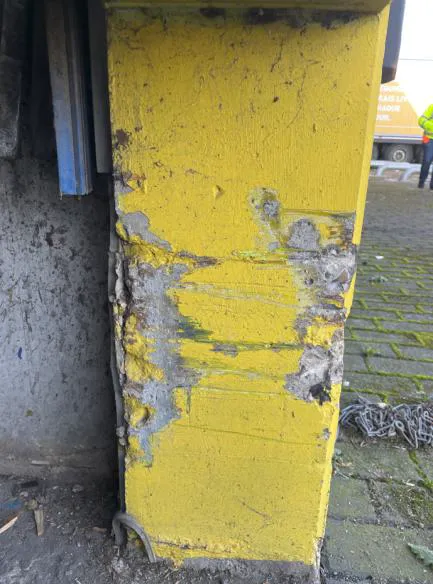 Détail d'un béton présentant des épaufrures, des éclats et une altération visible du matériau.